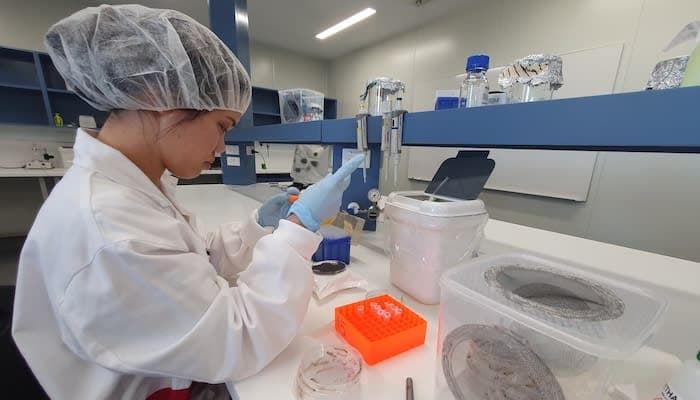 A woman in a lab coat is doing something