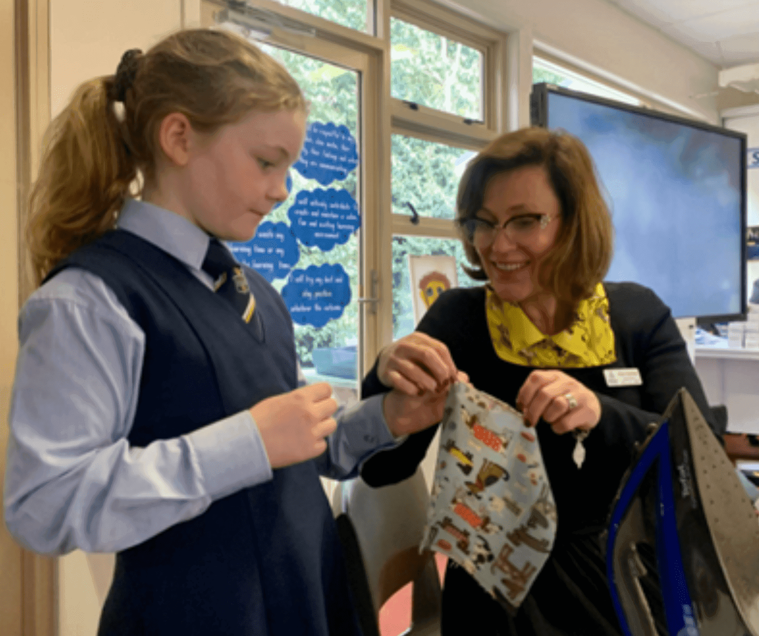A woman showing a girl how to tie a tie